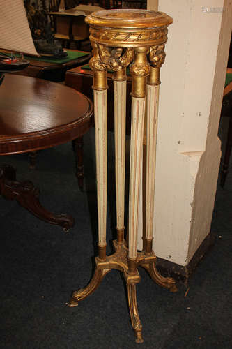 A carved giltwood jardiniere with circular top, on four cream painted reeded supports with