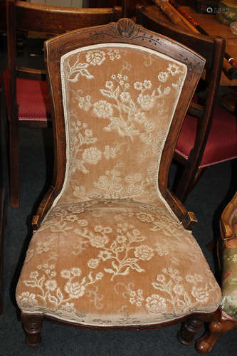 A Victorian upholstered nursing chair with shell carved surmount, on turned front legs