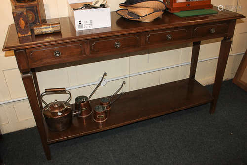 A mahogany veneered sideboard with narrow rectangular top and three drawers, with undershelf, on