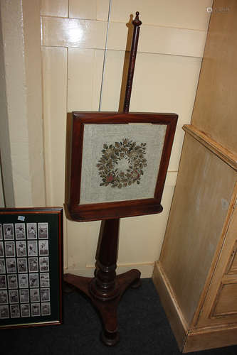 A Victorian mahogany adjustable fire screen, with glazed needlework panel on pole and turned wood