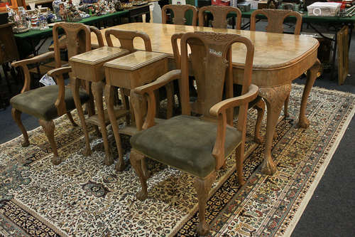 A reproduction carved walnut dining suite, comprising dining table with rectangular shaped top on