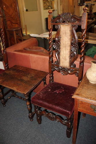 A pair of Carolean style carved oak high back chairs, with scroll panel back, turned uprights and