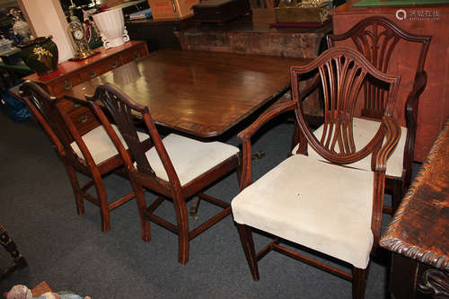 Three Sheraton style mahogany dining chairs including one carver, and another carver with shield