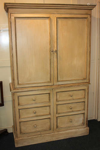 A cream painted cupboard with two panel doors enclosing two shelves, on base with two panel doors