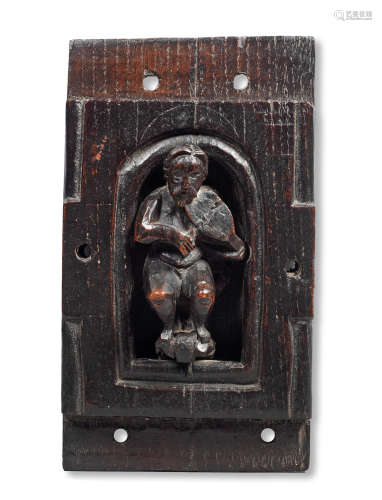 An early 17th century carved oak figure of a musician