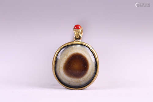 A TIBETAN SHEEP EYE BEAD GILT SILVER PENDANT