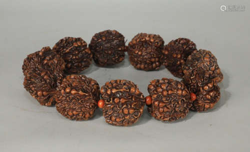 AN OLD WALNUT CARVED BEAD STRING BRACELET