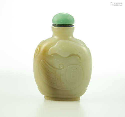 A finely carved celadon jade archaistic snuff bottle with russet skin