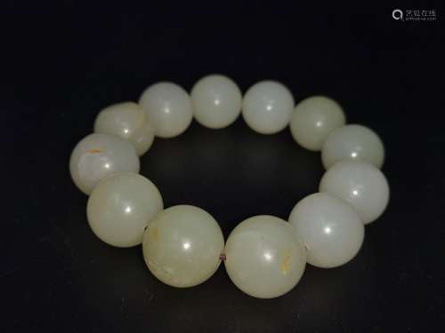 A BRACELET MADE OF 12 HE-TIAN JADE BEADS