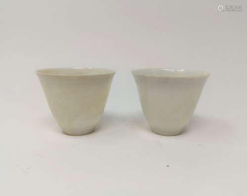 PAIR OF WHITE GLAZED CUPS WITH TRANSLUCENT MOTIFF