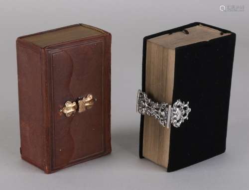 Two bibles, one with black cover and silver lock,