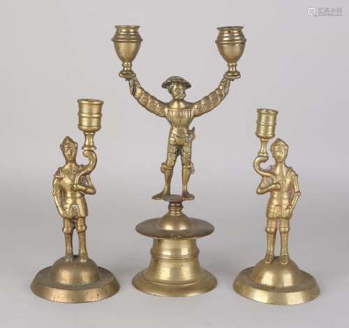 Three antique Renaissance-style brass candle holders.