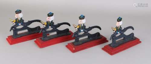 Four old metal nutcrackers with wooden base. 20th
