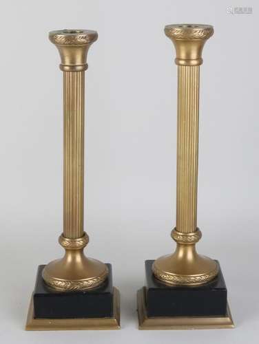 Two decorative brass candle holders with black marble