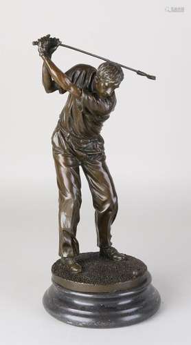 Old bronze golfer on black marble basement. 21st