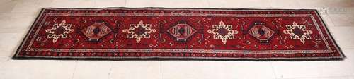 Old Persian runner in the colors red / cream / black.