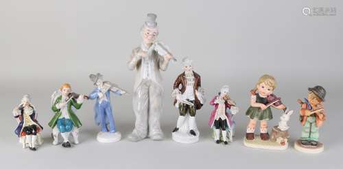 Eight old porcelain figures playing the violin. Among