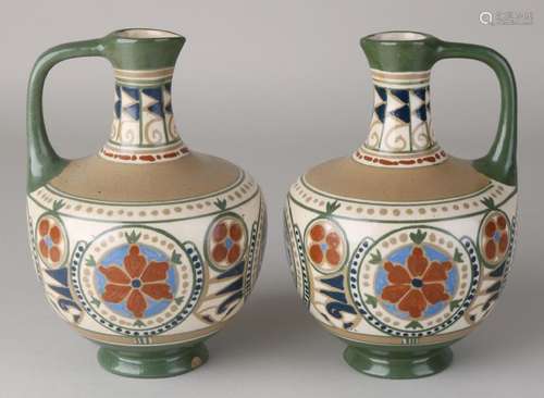 Two antique Arnhem pottery jugs with floral decor.