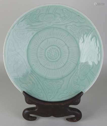 Ancient Chinese celadon dish with floral decor. On