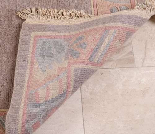 Old hand-knotted woolen rug. Pastel colored.