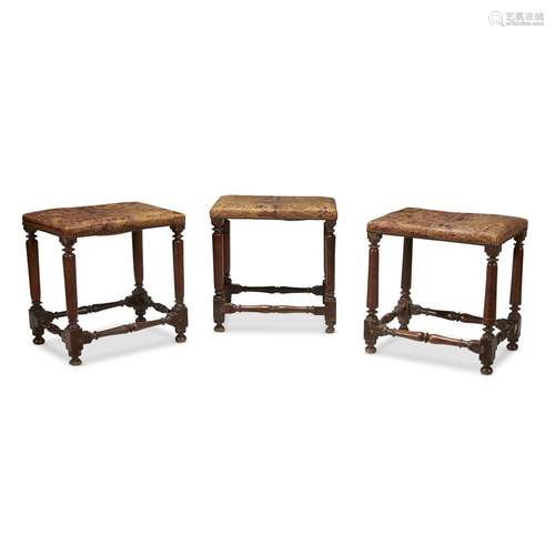 THREE EARLY SPANISH BAROQUE CARVED WALNUT FOOTSTOOLS WITH STAMPED AND GILT CORDOVAN LEATHER UPHOLSTERY