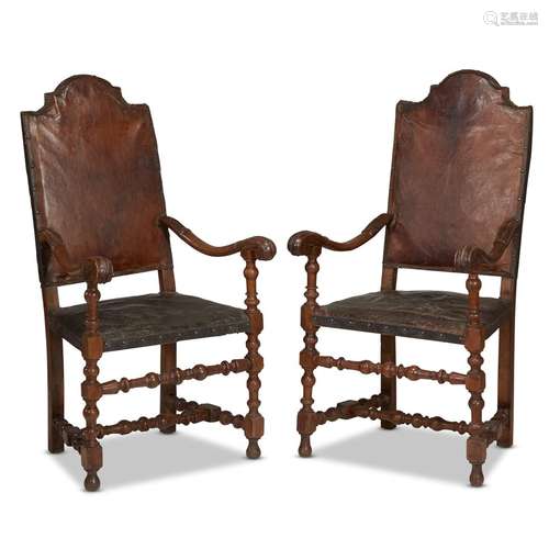 A PAIR OF SPANISH BAROQUE WALNUT LEATHER UPHOLSTERED ARMCHAIRS