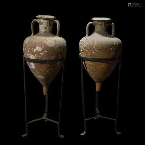 A PAIR OF ROMAN SEA SALVAGED AMPHORAE WITH WROUGHT IRON STANDS