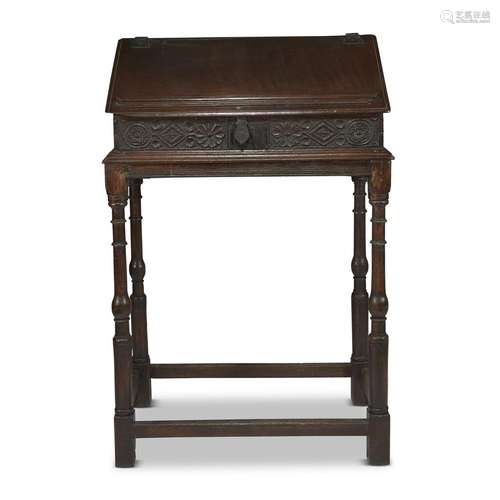 A CHARLES II CARVED OAK SLANT-FRONT TRAVELING DESK ON STAND