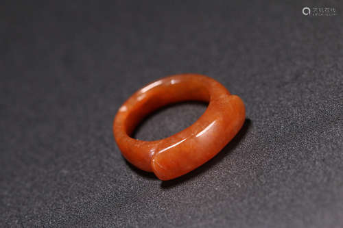 A RED-GLAZED SADDLE SHAPED JADE RING