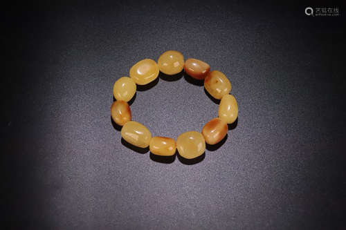 A STRING OF OLD NATURAL BEEWAX BRACELET