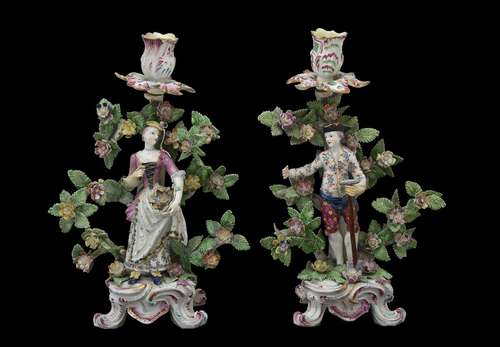 A pair of Bow figural candlesticks of a gardener and companion, circa 1765, modelled on scroll bases