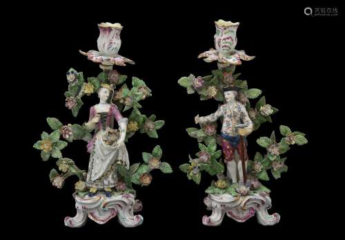 A pair of Bow figural candlesticks of a gardener and companion, circa 1765, modelled on scroll bases