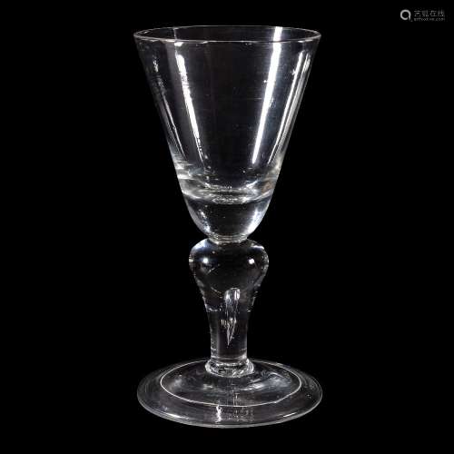 A baluster wine glass, first quarter 18th century, the round funnel bowl with solid basal section
