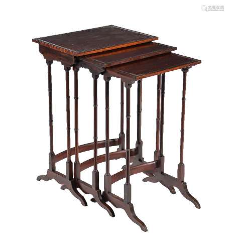 A nest of three Edwardian fiddle-back mahogany and ebonised tables in Regency style