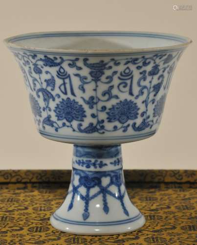 Porcelain stem cup. China. Ch'ien Lung mark. (1735-1795) and of the period. Underglaze blue decoration of floral scrolling and sanskrit characters. Age line. 4-1/4