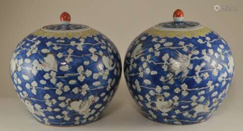 Pair of porcelain covered jars. China. 19th century. Oviform. Decoration of cranes and clouds on a blue ground. Ju-i border in yellow. Yung Ch'eng mark. 9-1/2