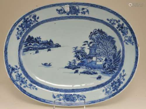 Porcelain platter. China. Circa 1800. Oval form. Underglaze blue decoration of a landscape and sprigs of flowers. 16-1/4