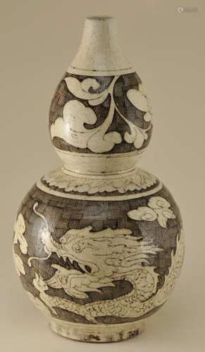 Stoneware vase. China. 19th century. Tzu Chou ware. Double gourd form. Decoration of dragons and clouds on a basket weave ground in black on cream colours. 13