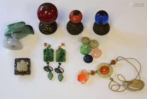 Lot of approximately ten items. China. Late 19th century. To include: A jade bird, three hat buttons (two from first rank officials), two pairs of jade earrings, a jade and carnelian pendant, a jade clip and others.