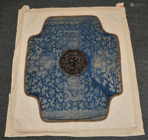 Throne cover. China. 18th century. Silver brocade on a blue ground. Decoration of five clawed dragons. Central gold brocade round of dragons on a black ground. 48