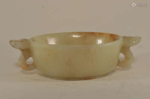 Jade wine cup. China. 19th century or earlier. Pale celadon colour with tan markings. Ling Chih handles. Surface engraved with flowers. 5