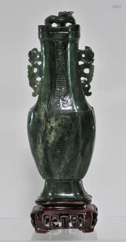 Jade covered jar. China. 20th century. Deep forest green stone. Surface carved with acada motifs. Phoenix handles. Chih lung finial. 8-3/4