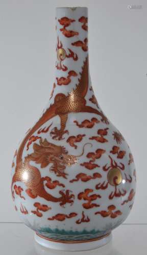 Porcelain vase. China. Kuang Hsu mark and period. (1875-1908). Iron red and gilt decoration of dragons, pearls and clouds above crashing waves. Hairlines and repairs to the mouth. 8-1/2