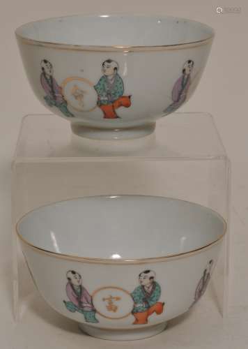 Pair of porcelain bowls. China. Circa 1930. Famille Rose decoration of pairs of children holding roundels with auspicious characters. 4-1/4