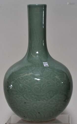 Porcelain vase. China. 19th century. Bottle form. Surface carved with dragons and Ling Chih. Sea green celadon glaze. 13