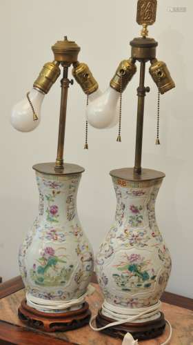 Pair of porcelain vases. Flattened baluster form. China. Circa 1800. Floral moulded decoration around reserves of birds and flowers. Famille Rose enameling. Drilled and mounted as lamps. 11-1/2