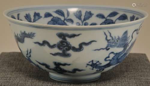 Porcelain bowl. China. 20th century. Underglaze blue decoration of floral scrolling on the interior. Exterior with dragons and  clouds. Hung Chih mark.  6