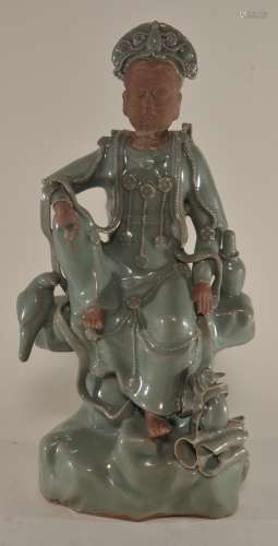 Stoneware figure. China. Ming period (1368-1644). Lung Chuan ware. Celadon glazed figure of Kuan Yin seated on a rocky throne with various attributes (parrot, vase, scroll and attendant. 13-1/2
