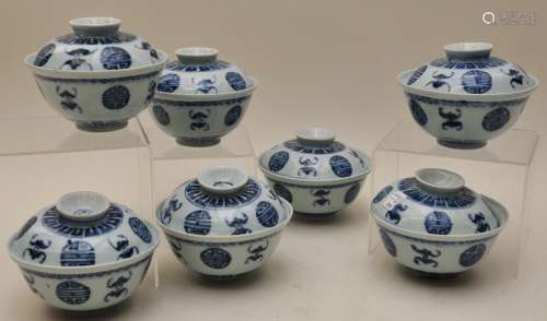 Lot of seven covered tea bowls. China. 19th century. Underglaze blue decoration of pairs of bats and shou characters. 4-1/2