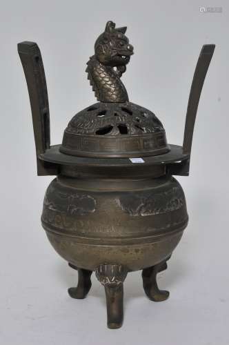 Bronze censer. China or Korea. Early 20th century. Dragon finial. Heaven soaring handles with foo dog tripod feet. Surface decorated in relief with engraving. 13